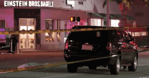 a black police car in front of a bagel shop