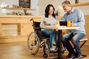 a woman in a wheelchair talking to a man