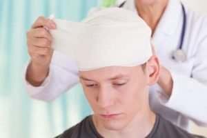 man having his head bandaged