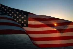 american flag in front of sun