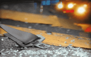 seatbelt on road with broken glass