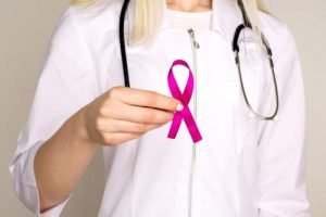 doctor holding up pink ribbon - personal injury lawyer