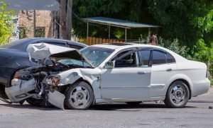 A damaged, white car after a head-on collision