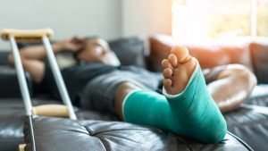 hombre acostado en la cama con un yeso en la pierna