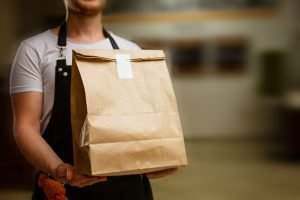 man presenting a bag of food