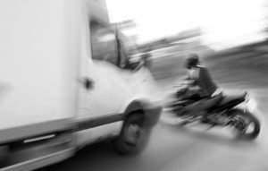 motociclista a punto de ser atropellado por un camión