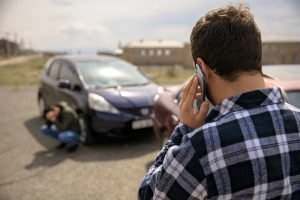 man calling roadside service after car crash