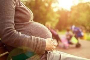 woman cradling her pregnant belly