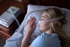young woman using a CPAP machine